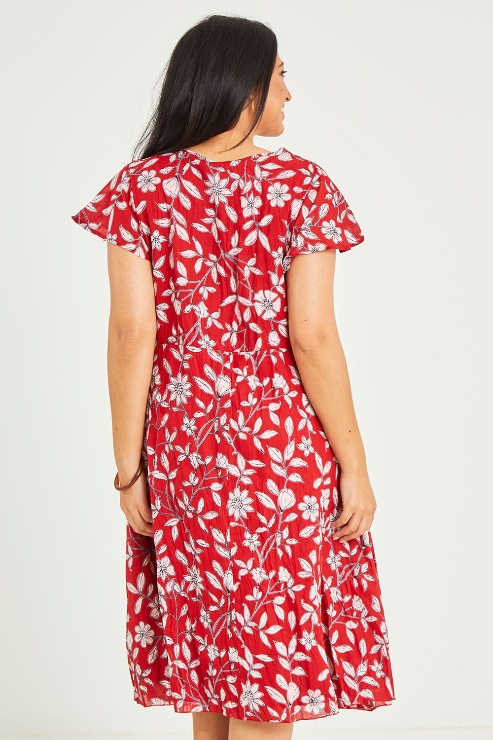 Model Terri-Leigh wearing size L of the Cotton Cap Sleeve Dress in colour Redprint (Red), from the back