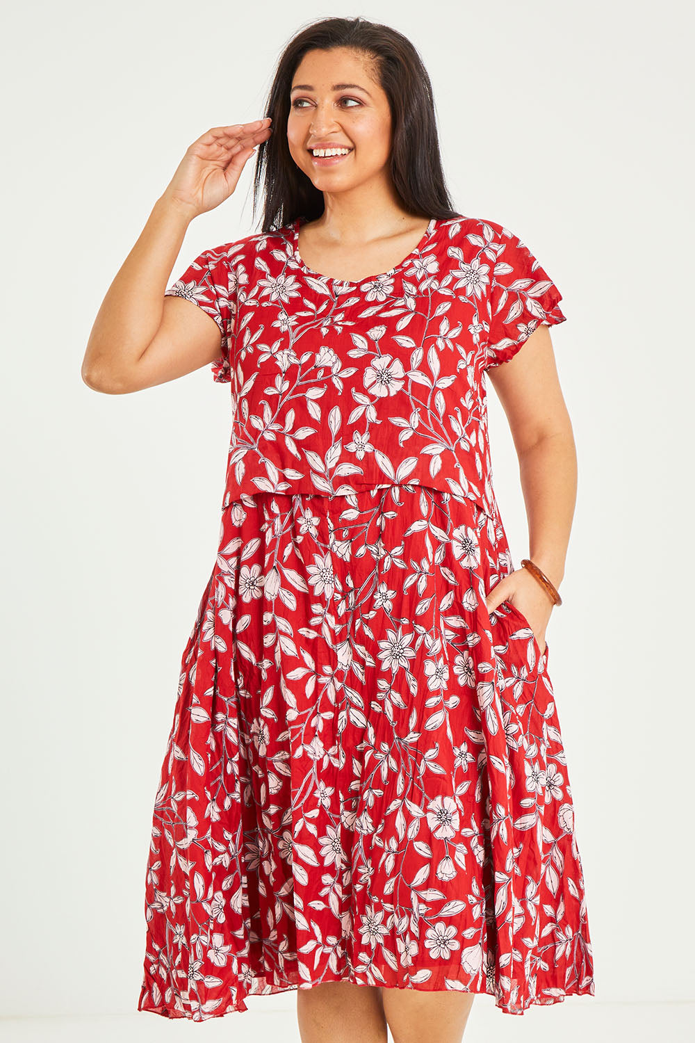 Model Terri-Leigh wearing size L of the Cotton Cap Sleeve Dress in colour Redprint (Red), from the front, cropped image