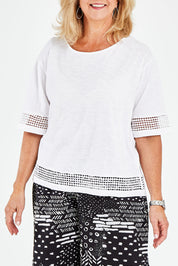 Model Sandy wearing size M of the Cotton Jersey Circle Trim Box Top in colour White (White), from the front, cropped image