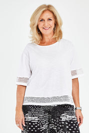 Model Sandy wearing size M of the Cotton Jersey Circle Trim Box Top in colour White (White), from the front, cropped image