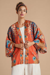 A model wearing the Kimono Jacket in colour Terracotta, from the front, cropped image