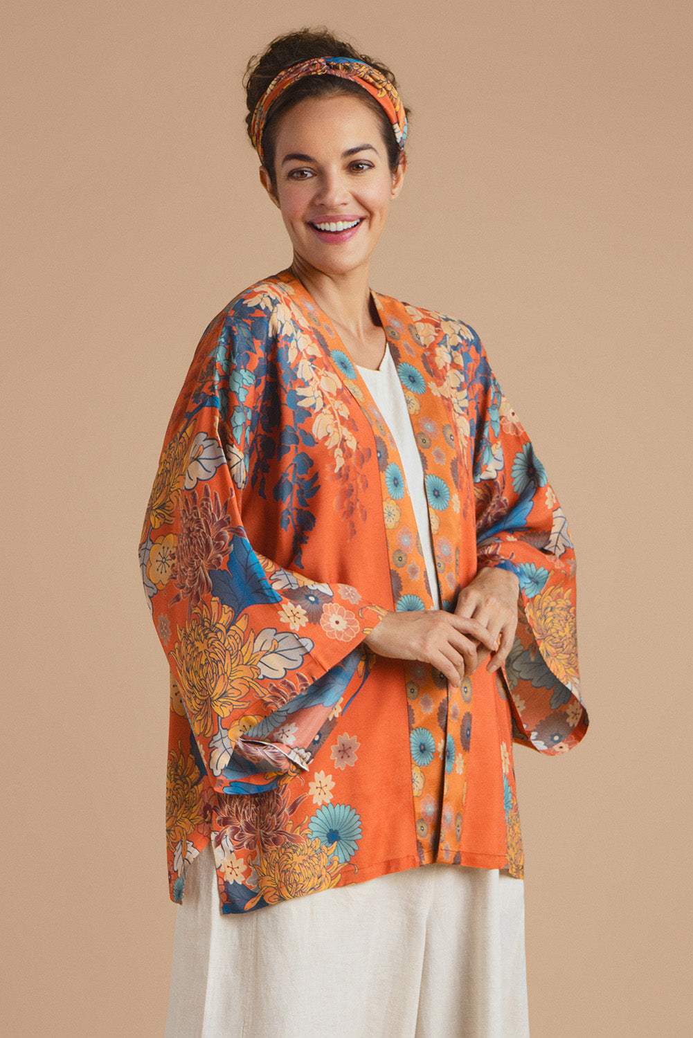 A model wearing the Kimono Jacket in colour Terracotta, from the front, cropped image
