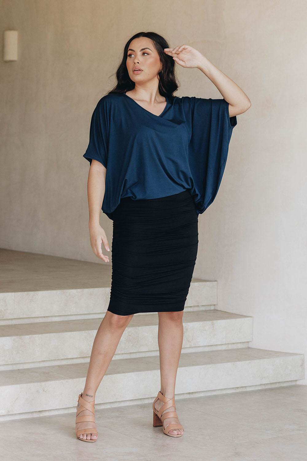 A model wearing the Ruche Skirt in colour Black (Black), from the front, showing the whole outfit