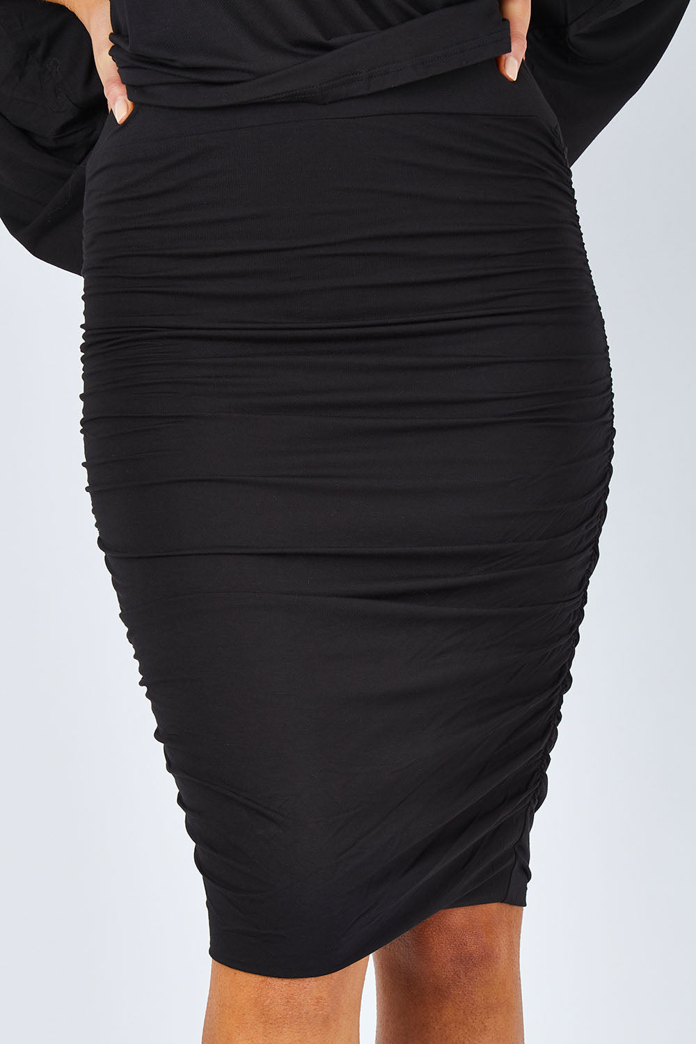 Model Madeline wearing size S of the Ruche Skirt in colour Black (Black), from the front, cropped image
