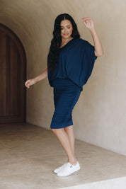 A model wearing the Ruche Skirt in colour Navy (Blue), from the front, showing the whole outfit