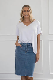 A model wearing the Frayed Denim Skirt in colour Blue (Blue), from the front, cropped image