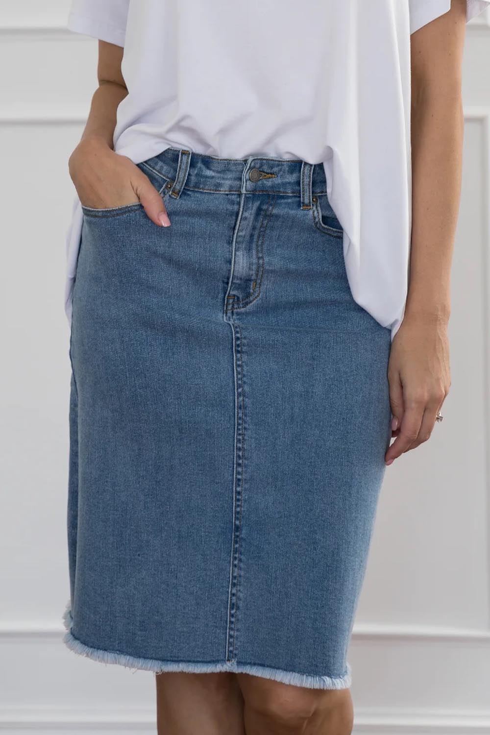 A model wearing the Frayed Denim Skirt in colour Blue (Blue), from the front, cropped image