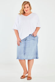 Model Caitlin wearing the Frayed Denim Skirt in colour Lightdenim (Blue), from the front, showing the whole outfit