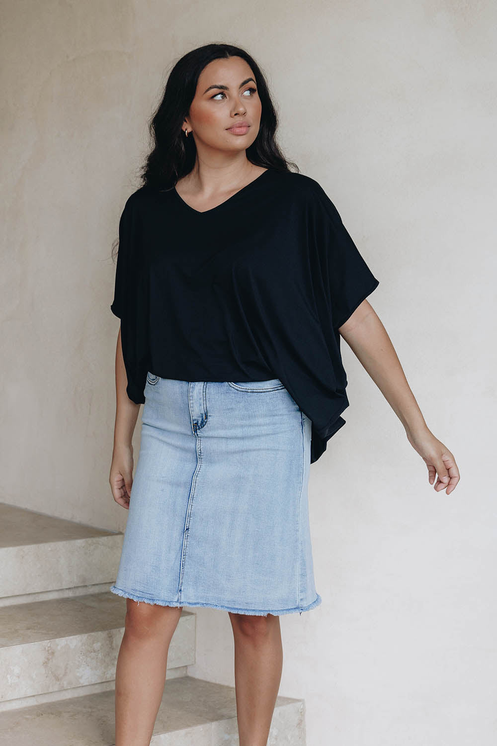 A model wearing the Frayed Denim Skirt in colour Lightdenim (Blue), from the front, showing the whole outfit
