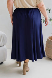 A model wearing the Adeline Bamboo Skirt in colour Navy (Blue), from the back