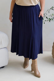 A model wearing the Adeline Bamboo Skirt in colour Navy (Blue), from the front, cropped image