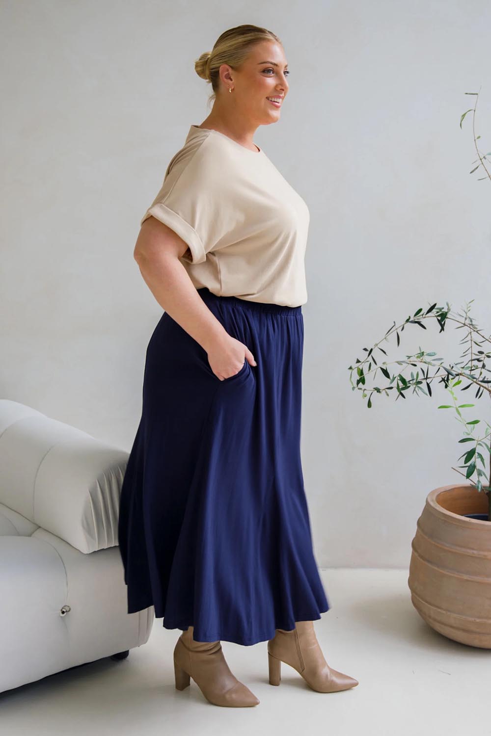 A model wearing the Adeline Bamboo Skirt in colour Navy (Blue), from the front, showing the whole outfit