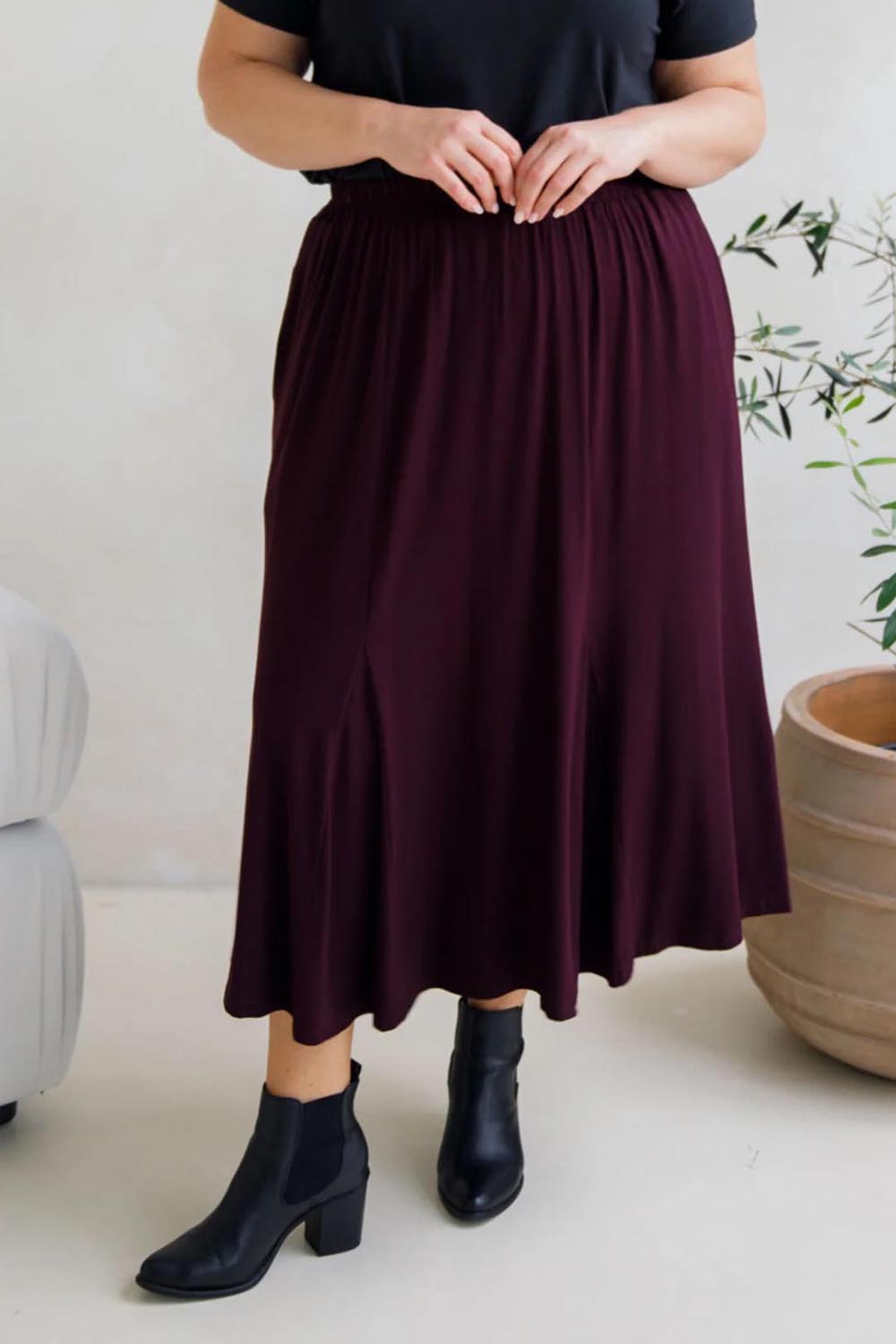 A model wearing the Adeline Bamboo Skirt in colour Shiraz (Purple), from the front, cropped image