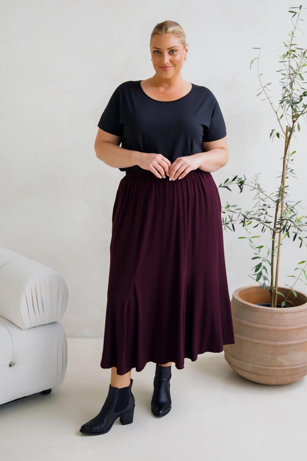 A model wearing the Adeline Bamboo Skirt in colour Shiraz (Purple), from the front, showing the whole outfit