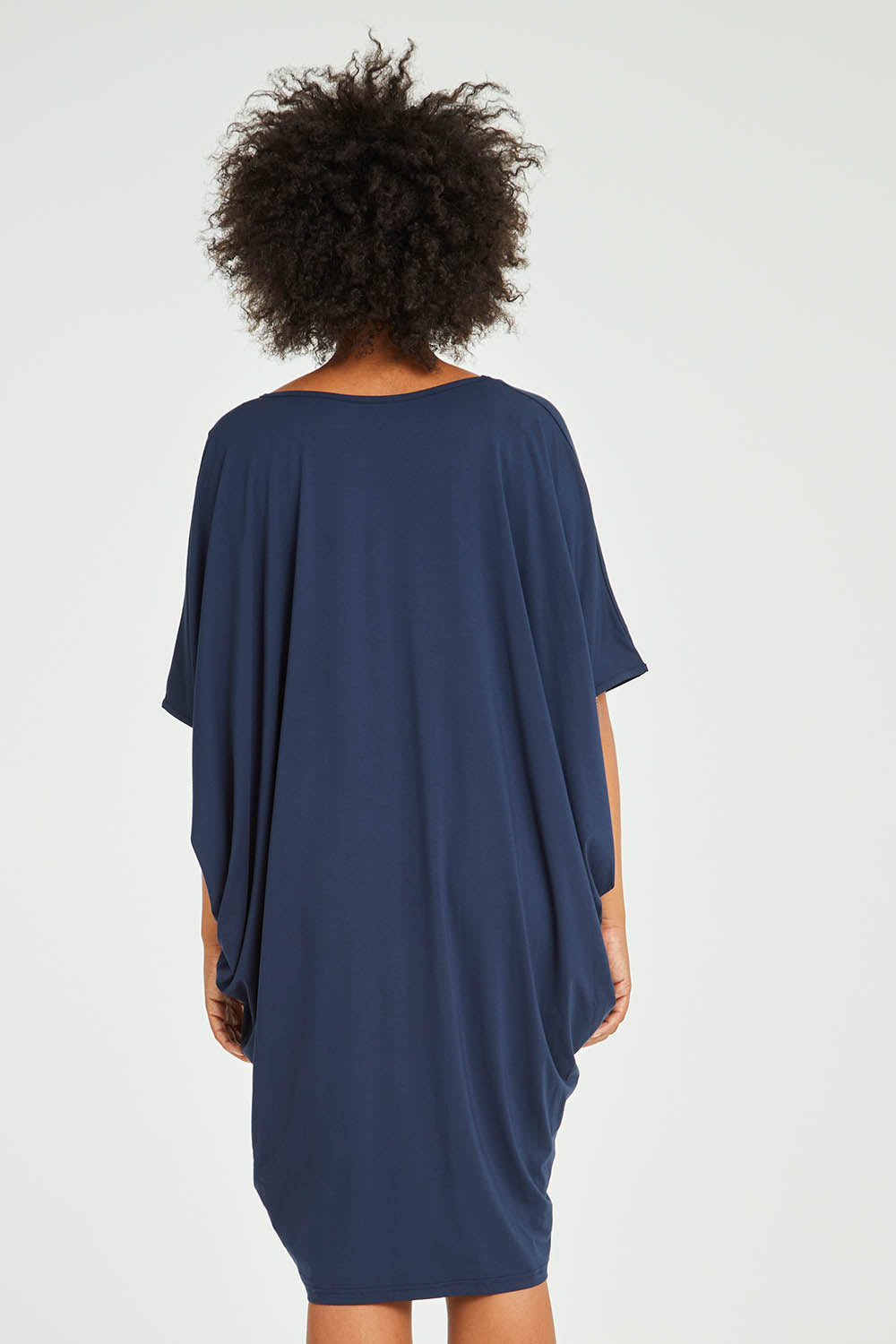 Model Olivia wearing size OneSize of the Original Miracle Dress in colour Navy (Blue), from the back