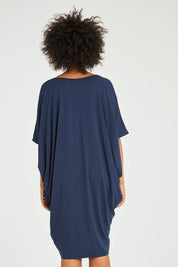 Model Olivia wearing size OneSize of the Original Miracle Dress in colour Navy (Blue), from the back