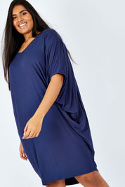 Model Shanaya wearing size OneSize of the Original Miracle Dress in colour Navy (Blue), from the front, cropped image
