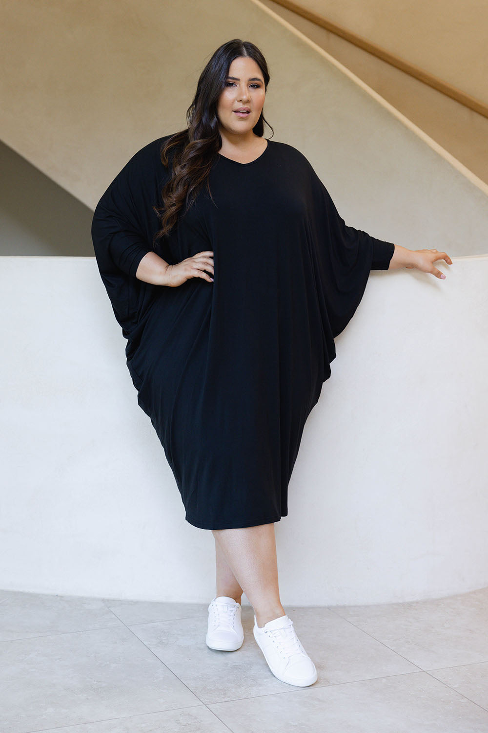 A model wearing the Long Sleeve Miracle Dress in colour Black (Black), from the front, showing the whole outfit