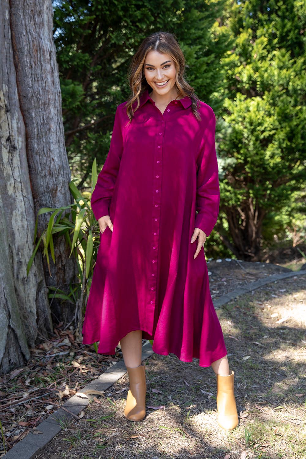 A model wearing the Cadillia Dress in colour Deepplum (Pink), from the front, showing the whole outfit