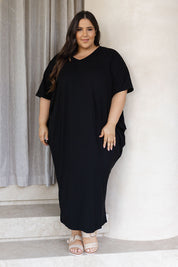 A model wearing the Maxi Miracle Dress in colour Black (Black), from the front, showing the whole outfit
