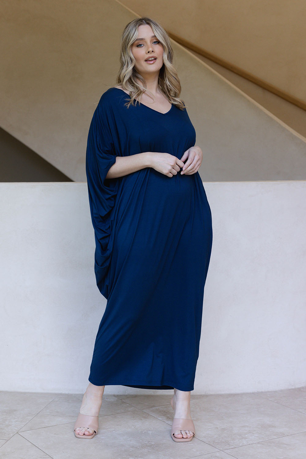 A model wearing the Maxi Miracle Dress in colour Navy (Blue), from the front, showing the whole outfit