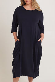 Model Chanel wearing the Alviva Lounge Dress in colour Navy (Blue), from the front, cropped image