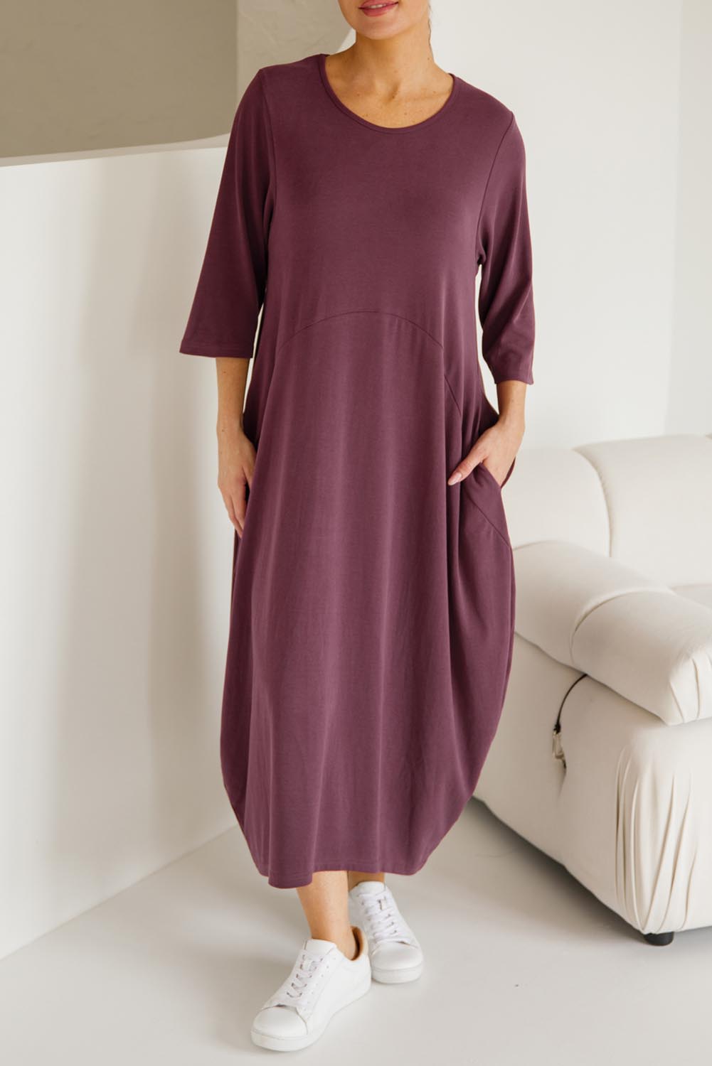 A model wearing the Alviva Lounge Dress in colour Shiraz (Purple), from the front, cropped image