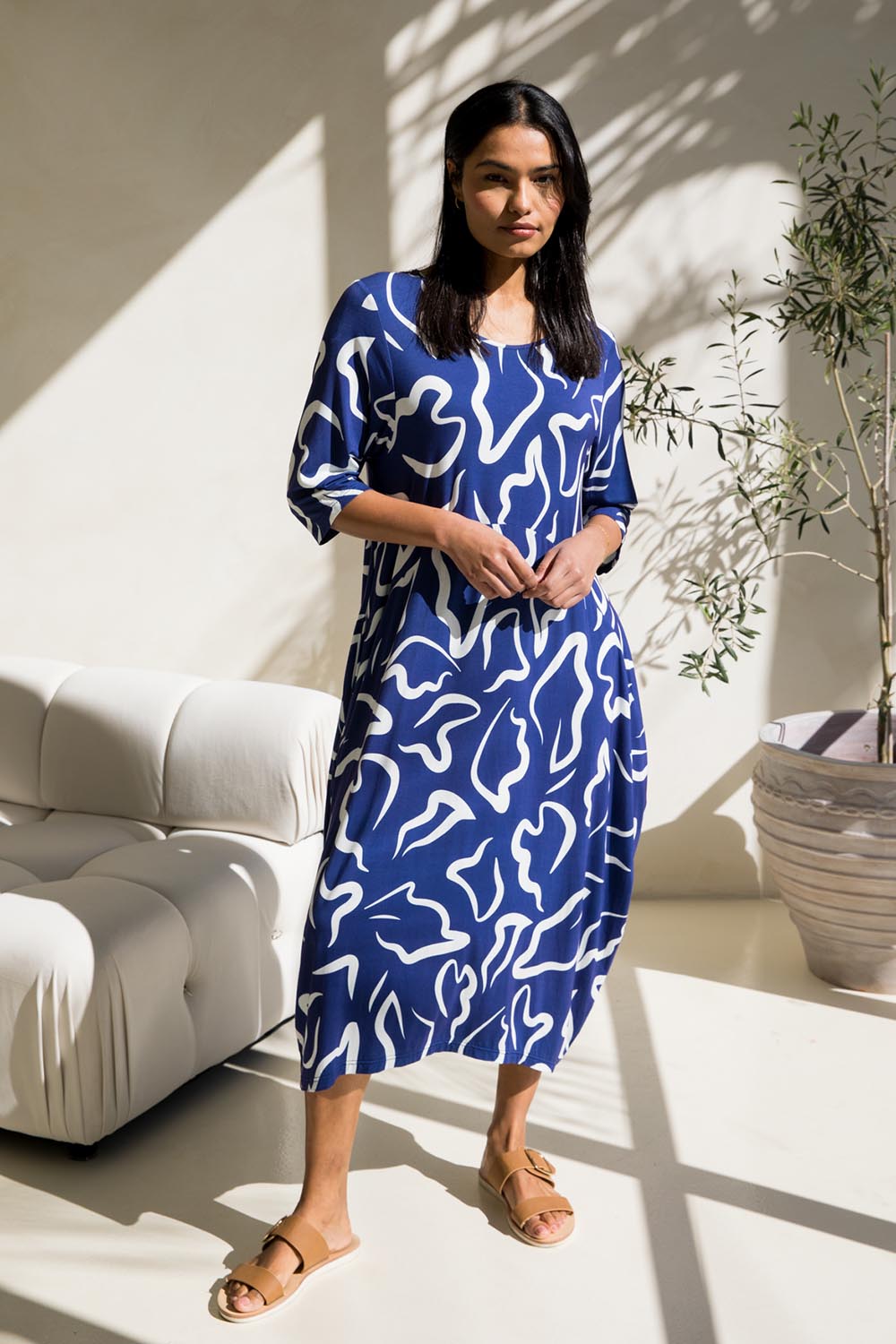A model wearing the Alviva Bamboo Dress in colour Seaport (Blue), from the front, showing the whole outfit