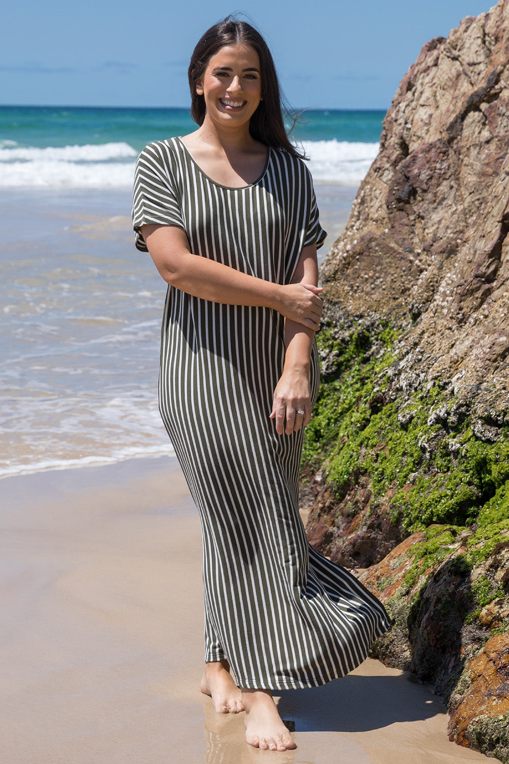 A model wearing the Destiny Dress in colour Green (Green), from the front, showing the whole outfit