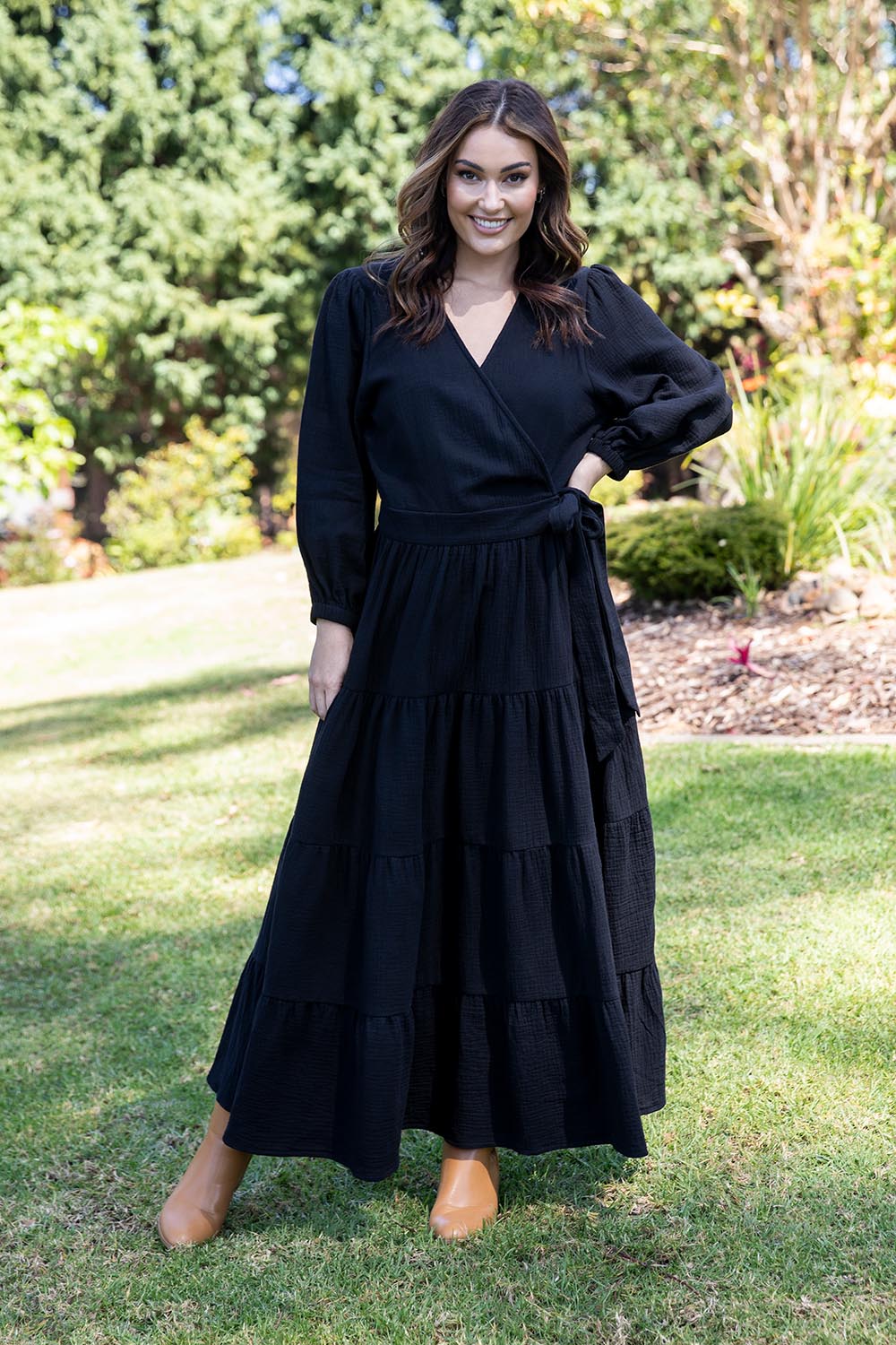 A model wearing the L/S Ruffle Wrap Dress in colour Black (Black), from the front, showing the whole outfit