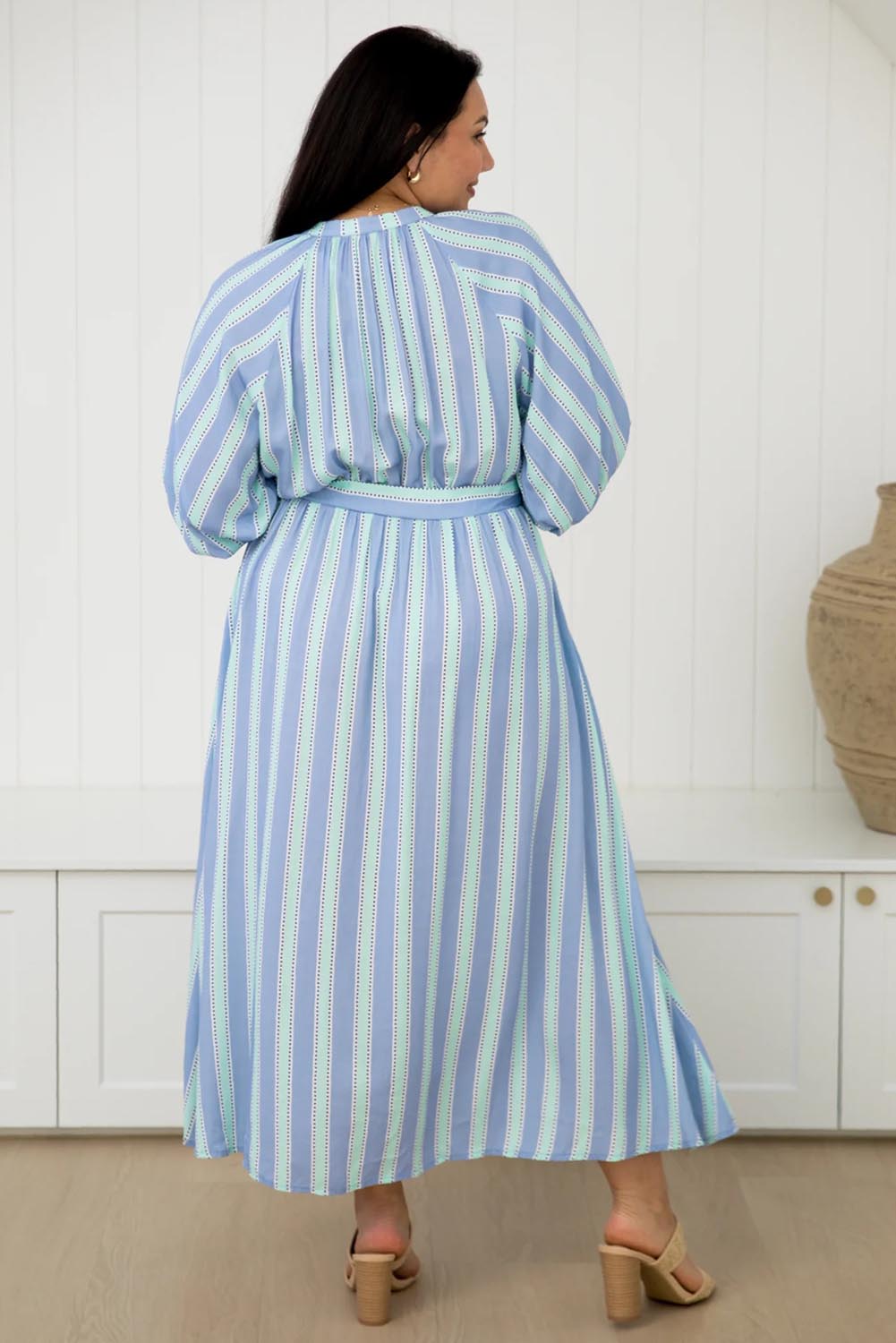 A model wearing the Athena Tencel Dress in colour Blue (Blue), from the back