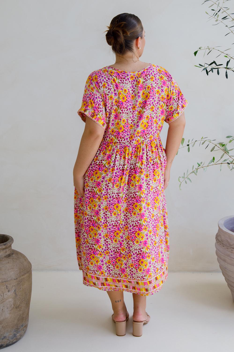 A model wearing the Frolic Dress in colour Harmony, from the back