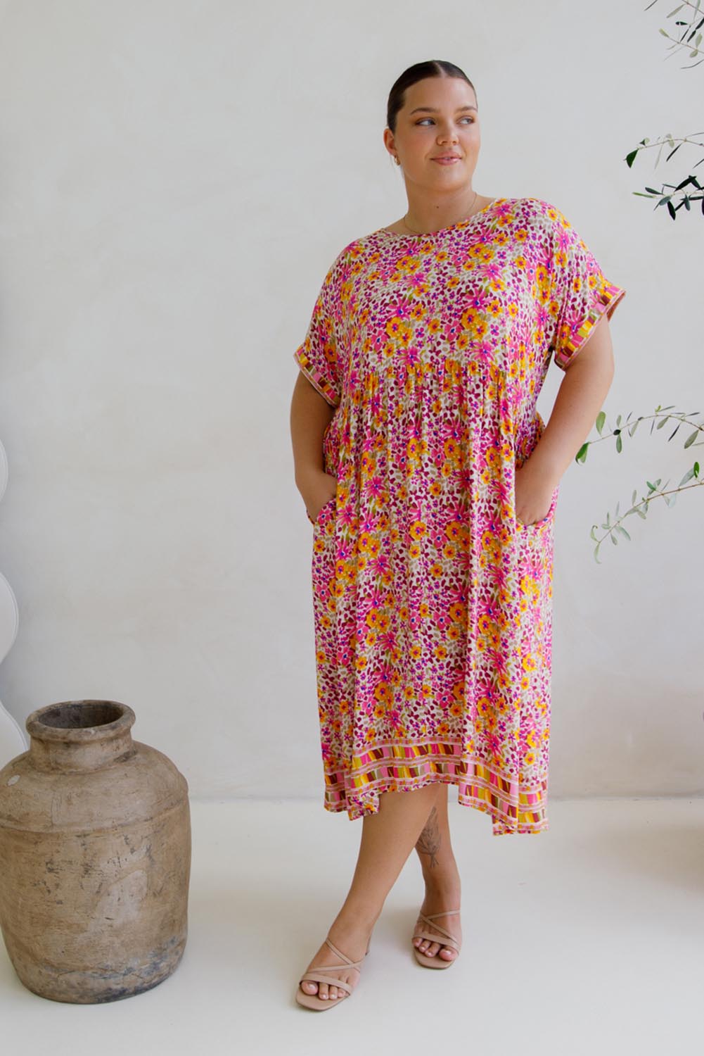 A model wearing the Frolic Dress in colour Harmony, from the front, showing the whole outfit