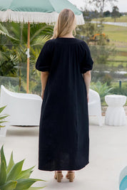 A model wearing the Novella Cotton Dress in colour Black (Black), from the back