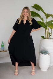 A model wearing the Novella Cotton Dress in colour Black (Black), from the front, showing the whole outfit