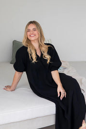A model wearing the Novella Cotton Dress in colour Black (Black), from the front, showing the whole outfit