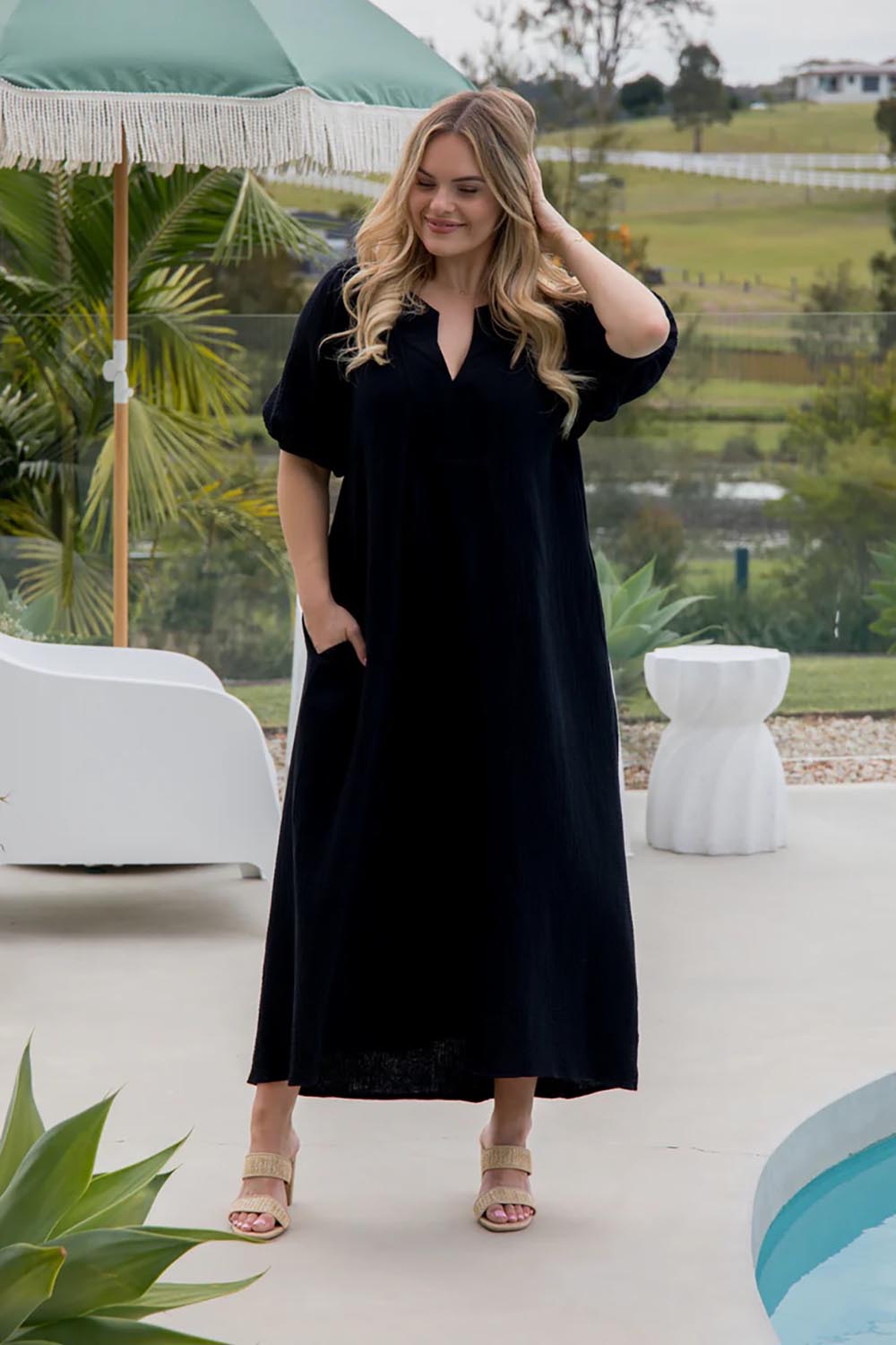 A model wearing the Novella Cotton Dress in colour Black (Black), from the front, showing the whole outfit