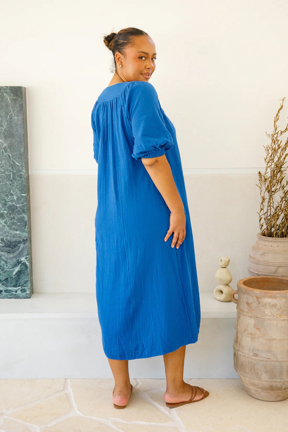 A model wearing the Novella Cotton Dress in colour Ultramarin (Blue), from the back