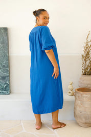A model wearing the Novella Cotton Dress in colour Ultramarin (Blue), from the back