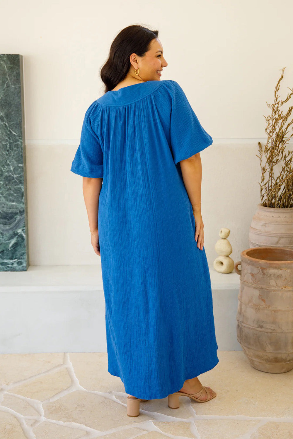 A model wearing the Novella Cotton Dress in colour Ultramarin (Blue), from the back