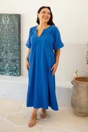 A model wearing the Novella Cotton Dress in colour Ultramarin (Blue), from the front, showing the whole outfit