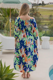 A model wearing the Ava Dress in colour Getaway (Blue), from the back
