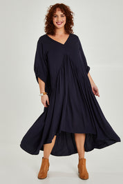 Model Maddy wearing the Long Sleeve Peak Maxi Dress in colour Navy (Blue), from the front, showing the whole outfit