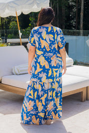 A model wearing the Peak Maxi Dress in colour Fruitpunch (Blue), from the back