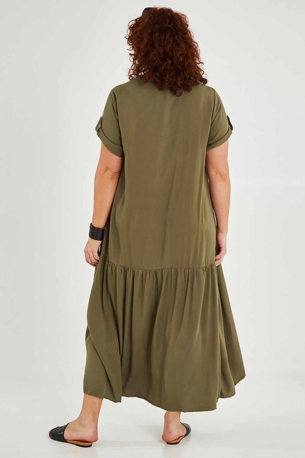 Model Maddy wearing the Short Sleeve Peak Maxi Dress in colour Khaki (Green), from the back