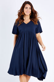 Model Laura wearing size M of the Wander Dress in colour Navy (Blue), from the front, cropped image