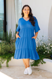 A model wearing the Chic Cotton Dress in colour Ultramarin (Blue), from the front, showing the whole outfit
