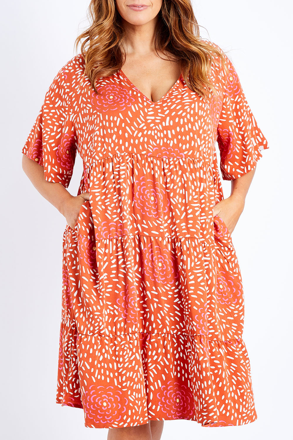 Model Laura wearing the Chic Dress in colour Corasplash (Pink), from the front, cropped image