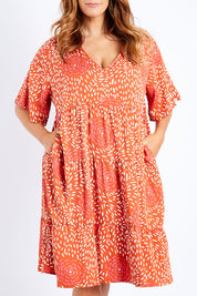 Model Laura wearing the Chic Dress in colour Corasplash (Pink), from the front, cropped image
