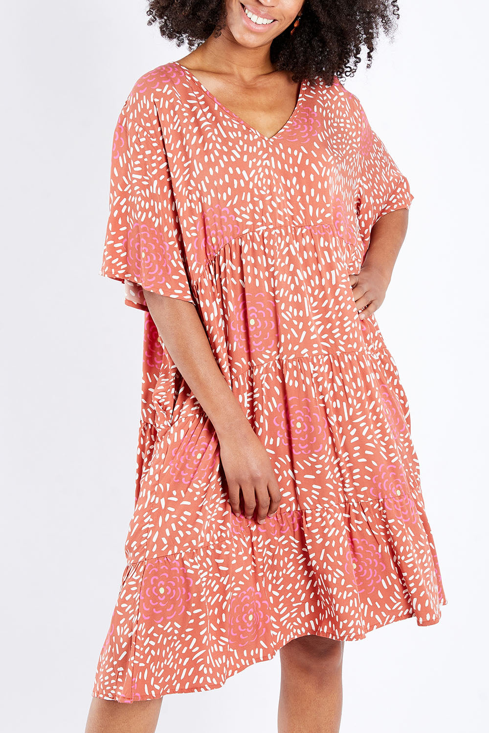 Model Schanez wearing the Chic Dress in colour Corasplash (Pink), from the front, cropped image